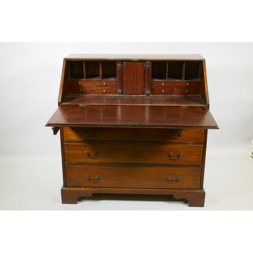 1028 - A Georgian mahogany bureau, the fall front with fitted interior over four long drawers with brass sw... 