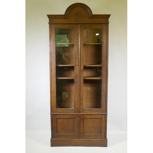 1029 - A C19th oak cabinet with arched top and two glazed doors over two cupboards, 90 x 30 x 210cm