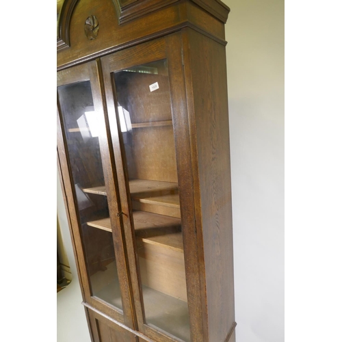 1029 - A C19th oak cabinet with arched top and two glazed doors over two cupboards, 90 x 30 x 210cm