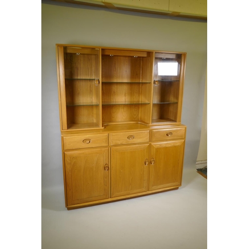 1035 - An Ercol elm Windsor high sideboard with two glazed doors to the upper section, and three drawers ov... 