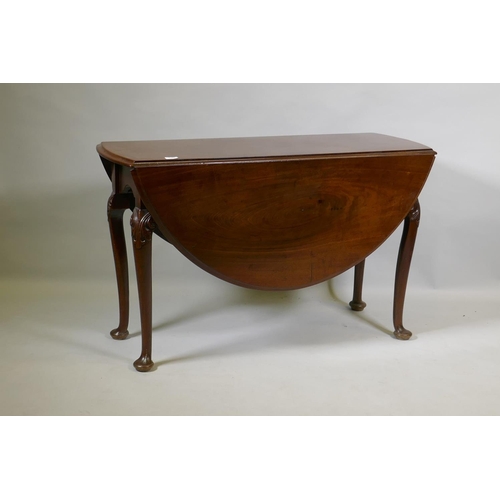 1049 - A Georgian mahogany drop leaf table, with oval top and shaped end frieze, raised on cabriole support... 