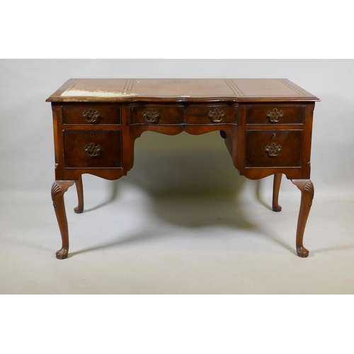 1056 - A Georgian style walnut five drawer kneehole desk with inset leather top, raised on cabriole support... 