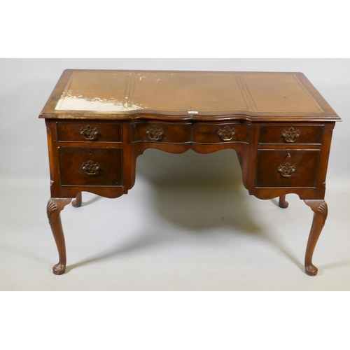 1056 - A Georgian style walnut five drawer kneehole desk with inset leather top, raised on cabriole support... 