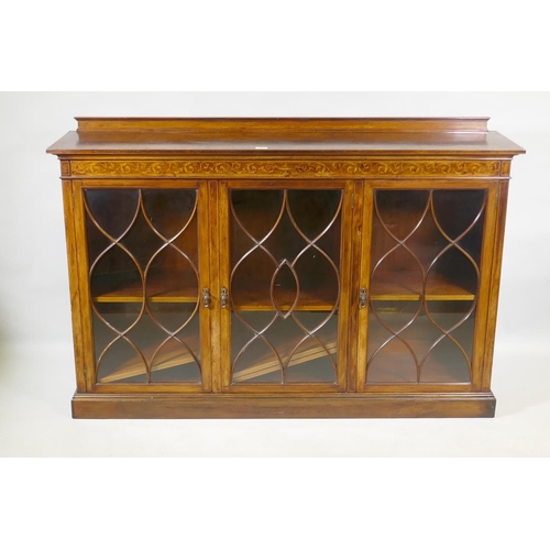 1064 - A Victorian mahogany bookcase, with inlaid frieze over three glazed doors, with five barred decorati... 