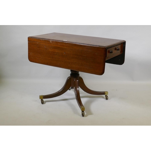 1069 - A Georgian mahogany pembroke table with one true and one false drawer, raised on a turned column and... 