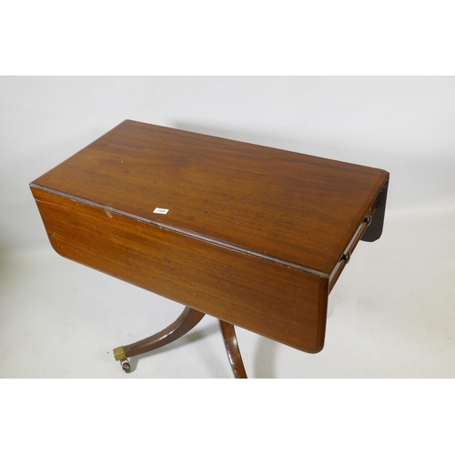 1069 - A Georgian mahogany pembroke table with one true and one false drawer, raised on a turned column and... 