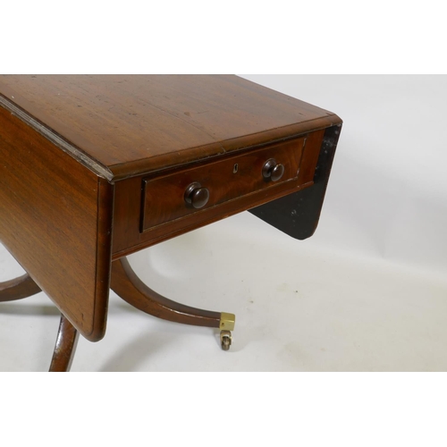 1069 - A Georgian mahogany pembroke table with one true and one false drawer, raised on a turned column and... 