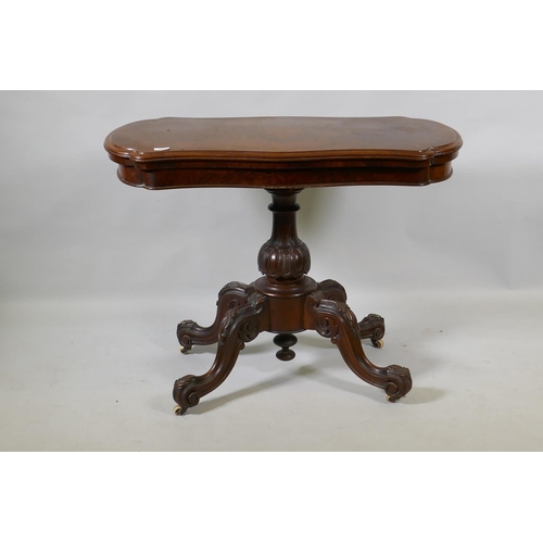 1070 - A Victorian burr walnut shaped top card table, raised on a carved and turned column and cabriole sup... 