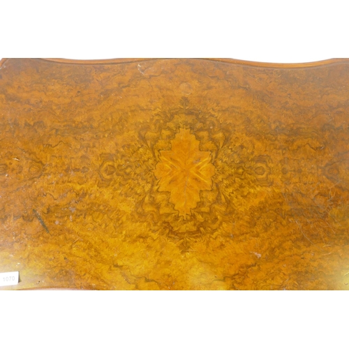 1070 - A Victorian burr walnut shaped top card table, raised on a carved and turned column and cabriole sup... 