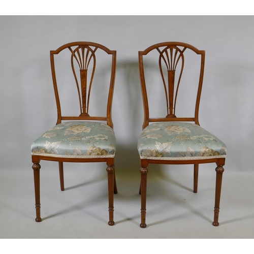 1072 - A pair of Victorian satinwood bedroom side chairs with pierced splats, raised on reeded supports (en... 