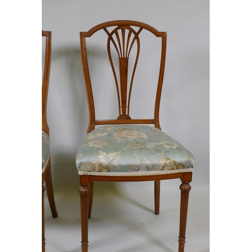 1072 - A pair of Victorian satinwood bedroom side chairs with pierced splats, raised on reeded supports (en... 