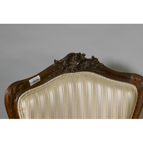 1074 - Two C19th French carved beechwood open armchairs, with shaped backs, raised on cabriole supports