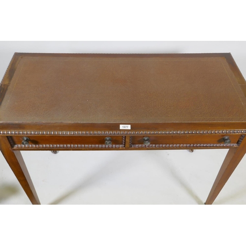 1077 - A C19th mahogany writing table, with inset faux leather top, carved bead edge over two drawers, rais... 