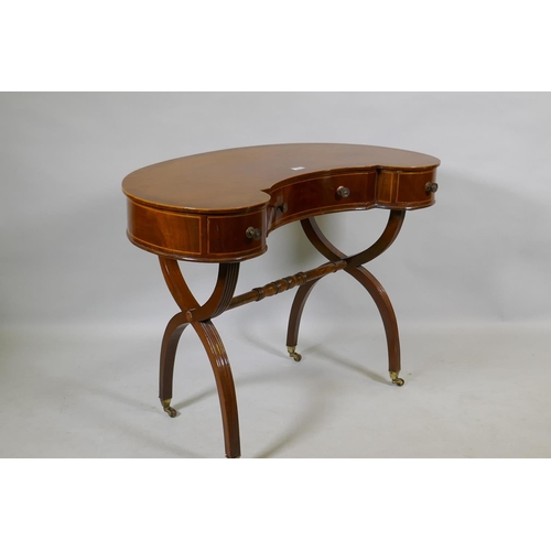 1079 - A Victorian inlaid mahogany kidney shaped desk/dressing table, raised on reeded cross frame end supp... 