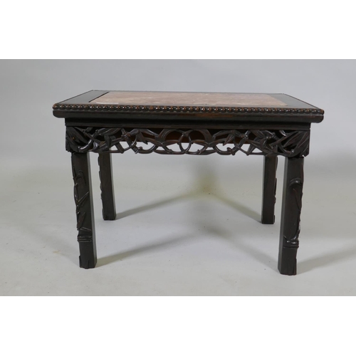 1080 - A Chinese carved and pierced hardwood table with an inset rouge marble top and bamboo shoot decorati... 