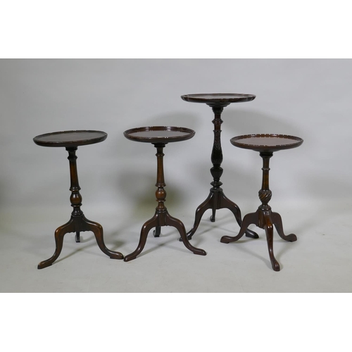 1083 - A pair of mahogany wine tables with dished tops, raised on turned columns with tripod supports, 27cm... 