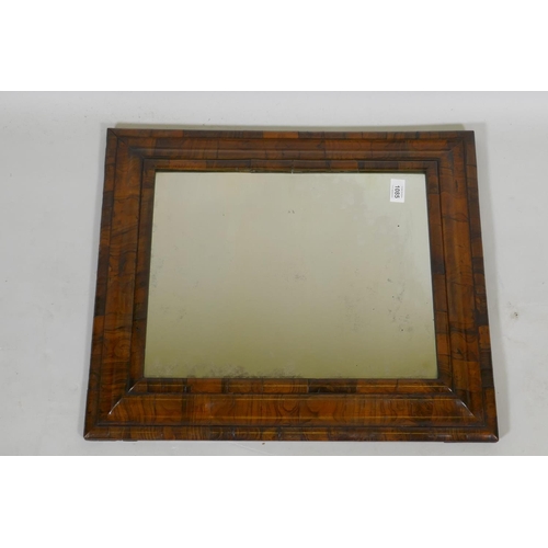 1085 - A William and Mary well figured walnut veneered cushion mirror with antique glass, 59 x 50cm