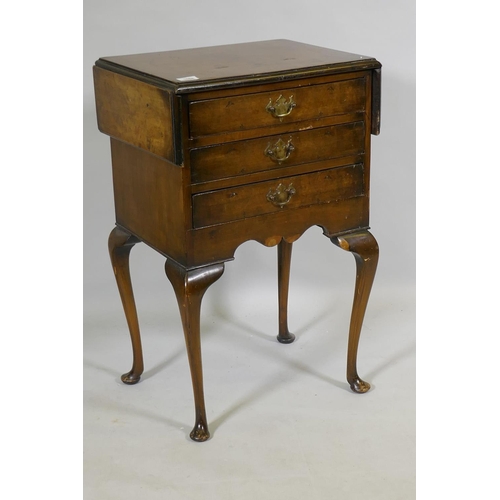 1088 - An early C20th Georgian style walnut work table, with drop flaps and three drawers, raised on cabrio... 