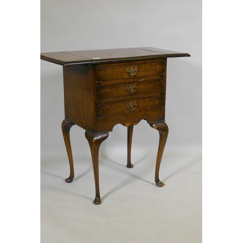 1088 - An early C20th Georgian style walnut work table, with drop flaps and three drawers, raised on cabrio... 