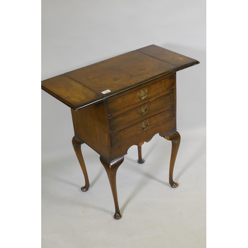 1088 - An early C20th Georgian style walnut work table, with drop flaps and three drawers, raised on cabrio... 