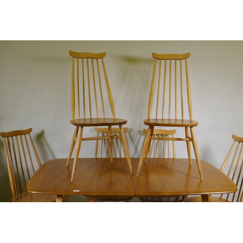 1090 - An Ercol Grand Windsor blond elm and beech extending dining table Model 444, and six matching Ercol ... 