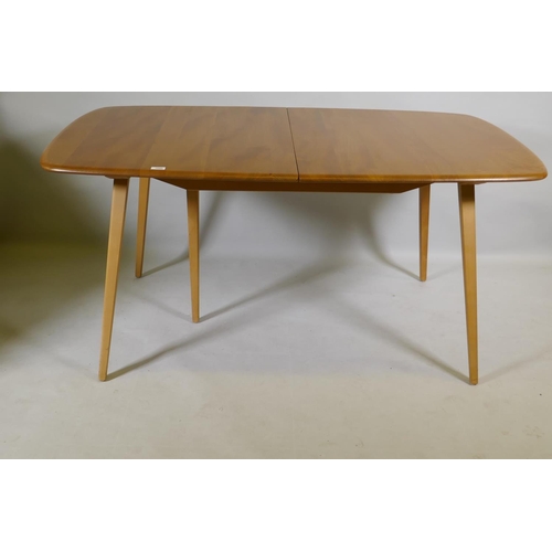 1090 - An Ercol Grand Windsor blond elm and beech extending dining table Model 444, and six matching Ercol ... 