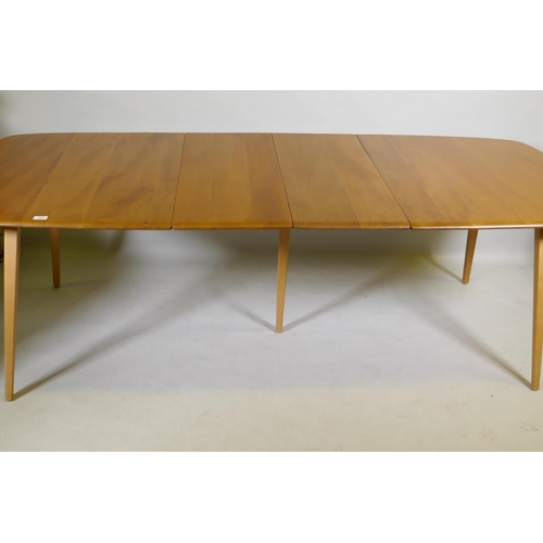 1090 - An Ercol Grand Windsor blond elm and beech extending dining table Model 444, and six matching Ercol ... 