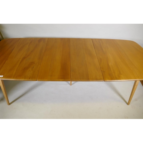 1090 - An Ercol Grand Windsor blond elm and beech extending dining table Model 444, and six matching Ercol ... 