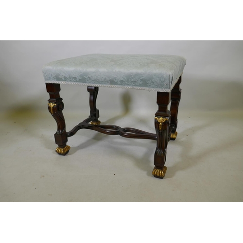 1098 - A mahogany stool with carved and parcel gilt decoration, raised on shaped and scrolled supports unit... 