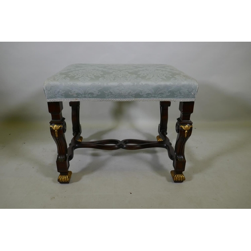 1098 - A mahogany stool with carved and parcel gilt decoration, raised on shaped and scrolled supports unit... 