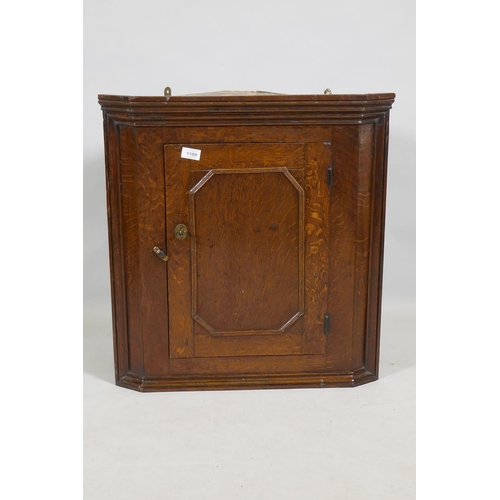 1109 - A Georgian oak hanging corner cupboard of small proportions, 66cm high