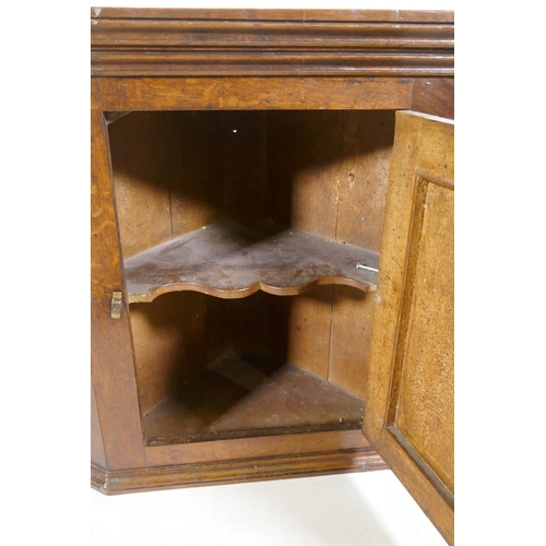 1109 - A Georgian oak hanging corner cupboard of small proportions, 66cm high