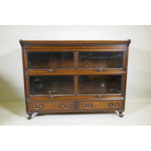 1111 - A Globe Wernicke style oak bookcase, two sections on a base of two drawers, raised on cabriole suppo... 