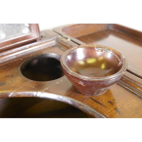 1119 - A Georgian mahogany gentleman's washstand, the fold out top with fitted interior and turned wood bow... 