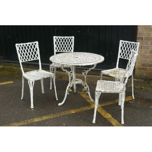 1129 - A painted metal garden table and four chairs with faux bamboo decoration and trellis backs, 80cm dia... 