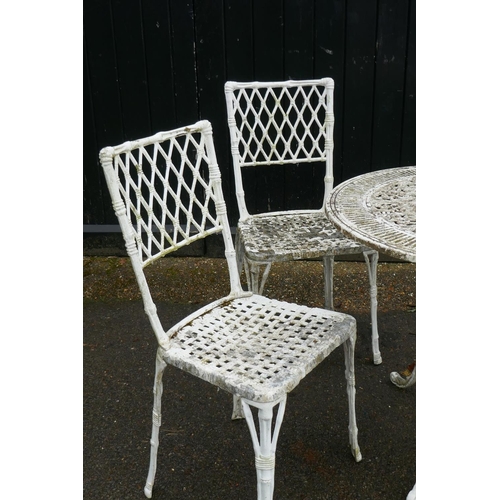 1129 - A painted metal garden table and four chairs with faux bamboo decoration and trellis backs, 80cm dia... 