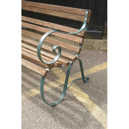 1136 - A painted wrought iron slatted garden bench, 152cm wide