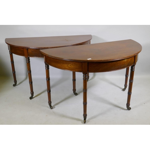 1138 - A pair of Georgian mahogany demi lune side tables with moulded edge tops, raised on ring turned tape... 