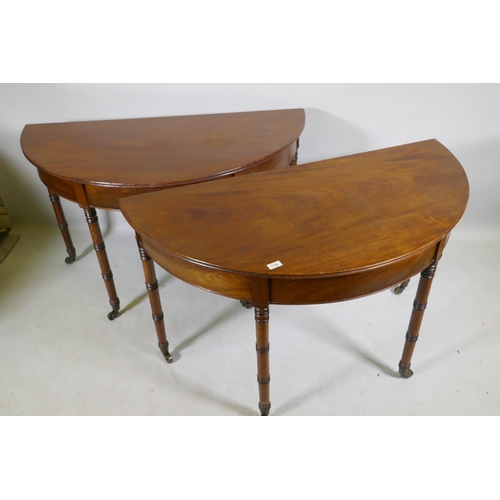 1138 - A pair of Georgian mahogany demi lune side tables with moulded edge tops, raised on ring turned tape... 