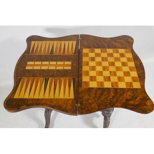 1139 - A Victorian serpentine shaped burr walut work box/games table, the top opening to reveal a chequer b... 