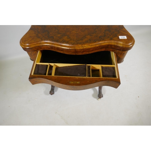 1139 - A Victorian serpentine shaped burr walut work box/games table, the top opening to reveal a chequer b... 