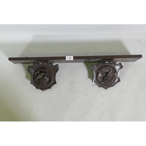 1148 - An C18th/C19th French oak shelf with carved brackets decorated with a bird and an angel, 72 x 13 x 1... 