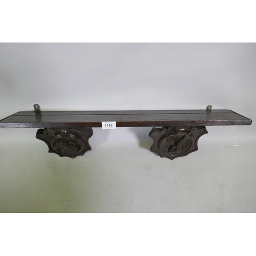 1148 - An C18th/C19th French oak shelf with carved brackets decorated with a bird and an angel, 72 x 13 x 1... 