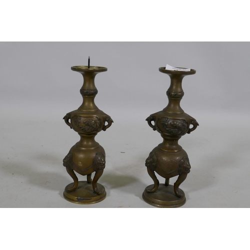 116 - A pair of Oriental brass pricket candlesticks, raised on tripod supports, 20cm high