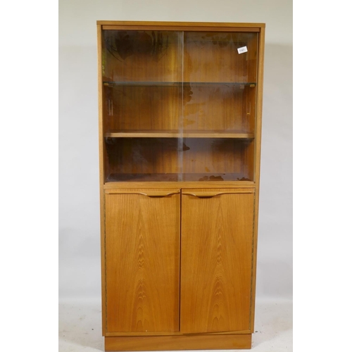 1161 - A mid century teak cabinet, with sliding glass doors over two cupboards, 69 x 36 x 144cm