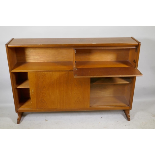 1164 - A mid century Nathan teak bookcase with open shel and fall front over two sliding doors, raised on s... 