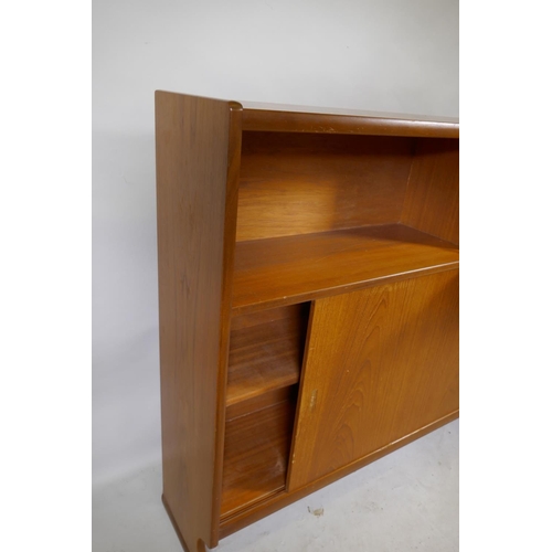 1164 - A mid century Nathan teak bookcase with open shel and fall front over two sliding doors, raised on s... 