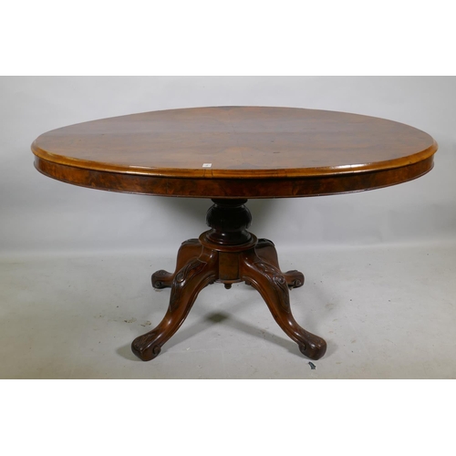 1169 - A Victorian figured walnut tilt top breakfast table, the oval top raised on a carved and turned colu... 