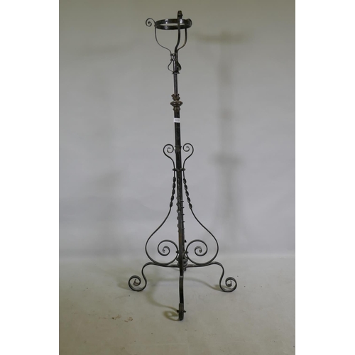 1173 - A Victorian wrought iron and brass telescopic standard lamp base with oil lamp basket, 140cm high, 1... 