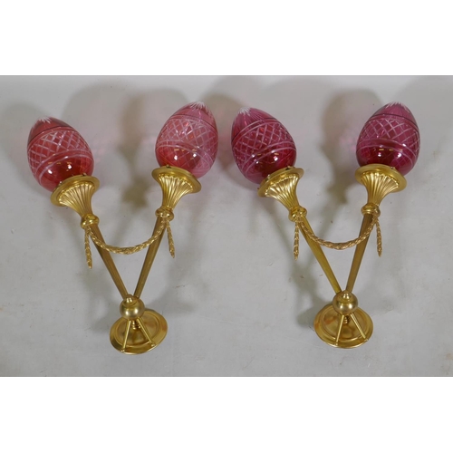 118 - A pair of ormolu two branch wall lights with cranberry glass shades, 57cm long